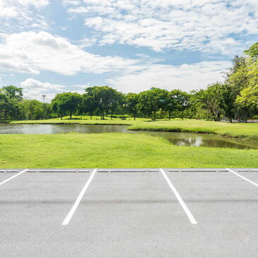 Freie Parkplätze vor einem Park mit See