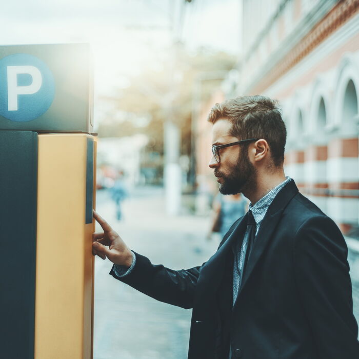 Mann steht vor Parkscheinautomat